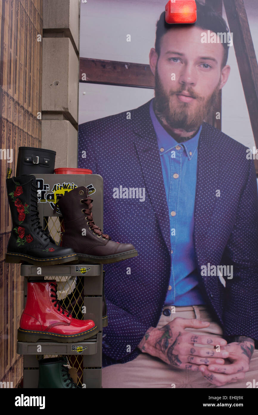 Dr Martens boots and construction hoarding featuring suited young man for dress hire business Moss Bros in central London. Stock Photo