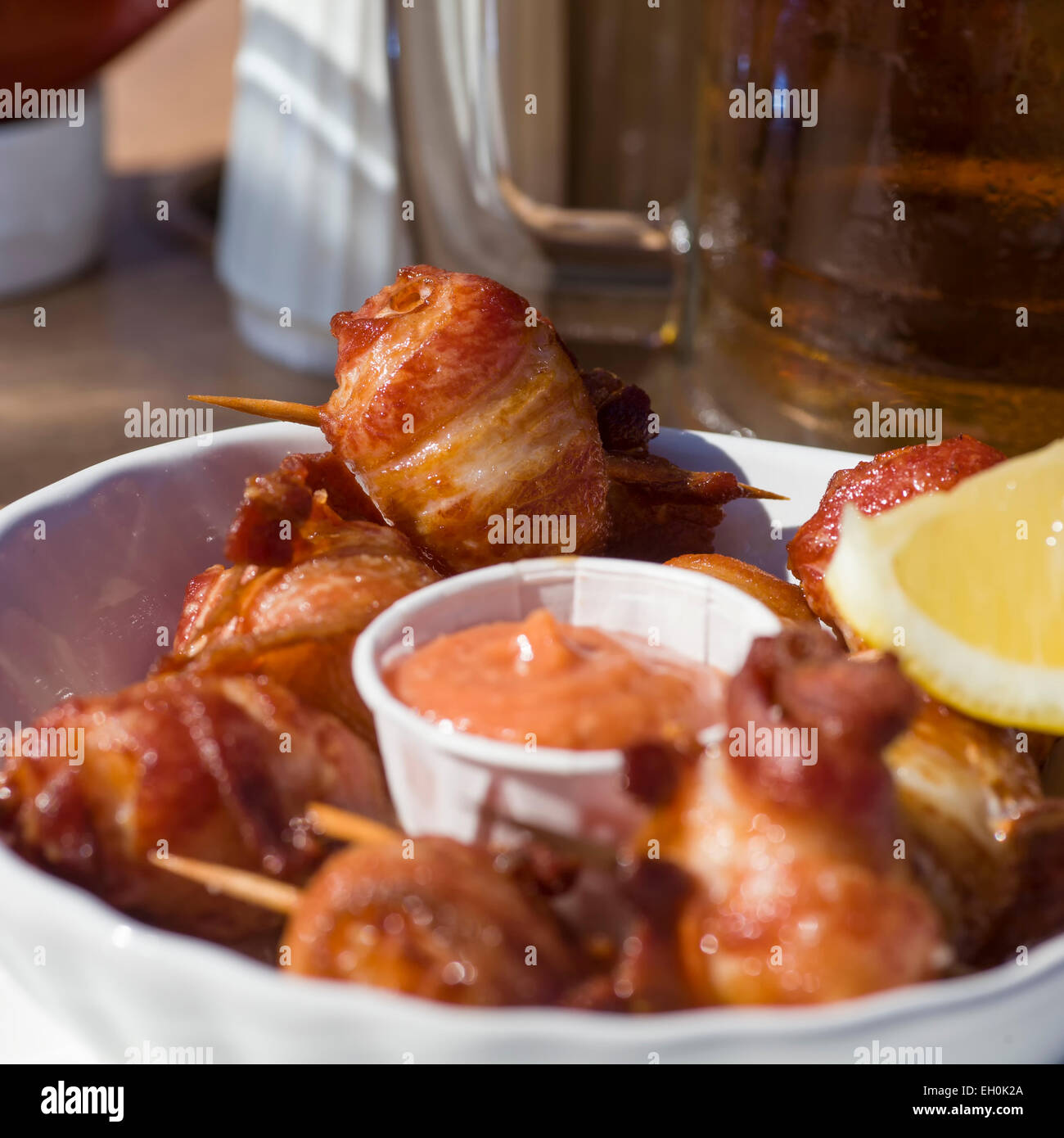 Deep fried bacon wrapped scallops with seafood sauce and lemon at an