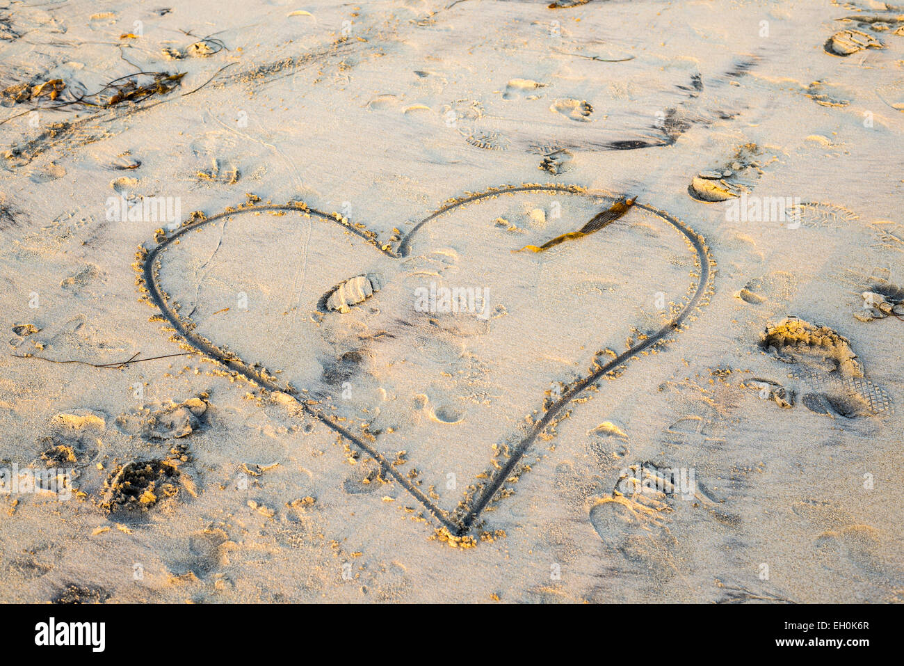 A heart shape carved in the sand on a beach. Stock Photo