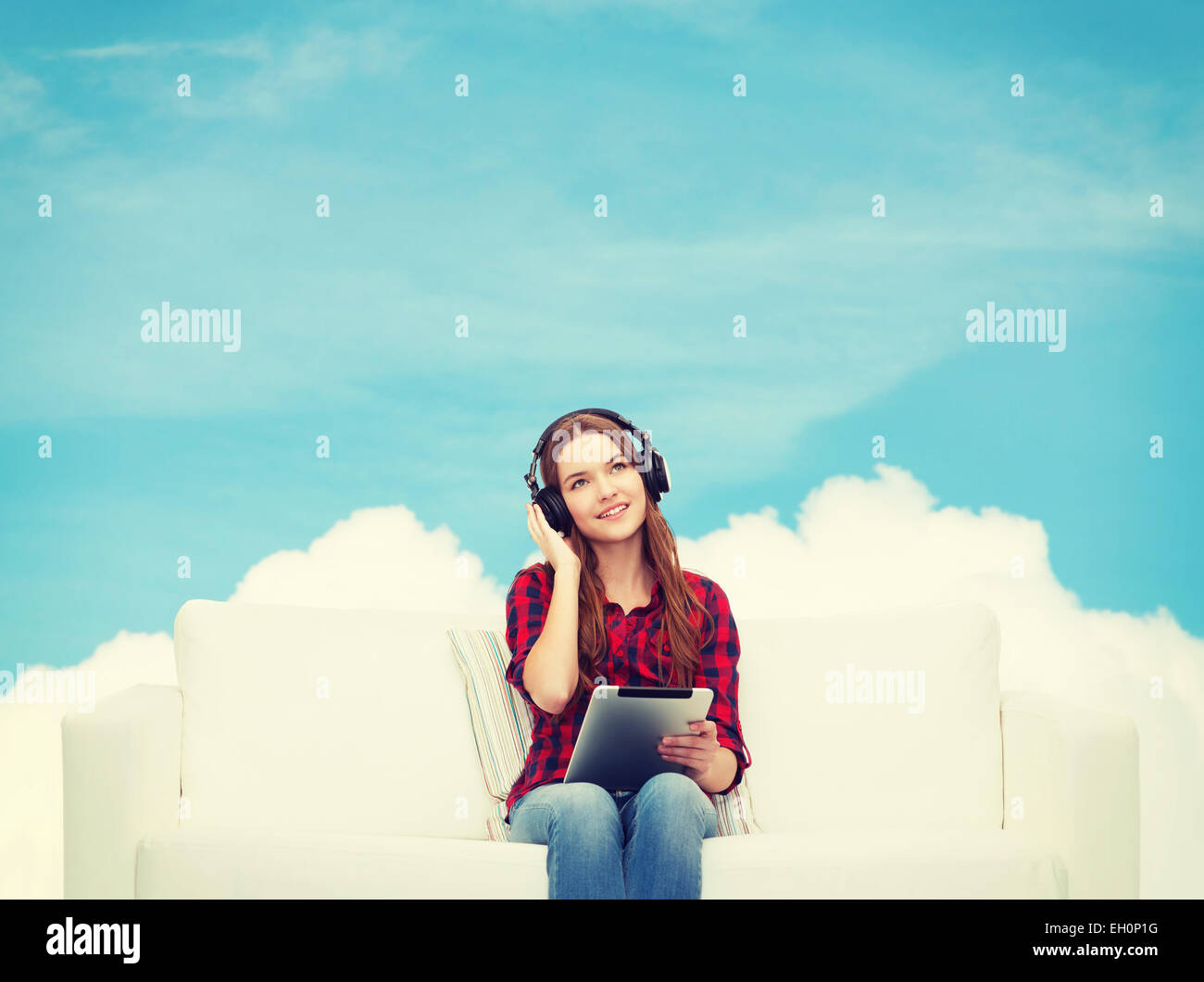 girl sitting on sofa with headphones and tablet pc Stock Photo - Alamy