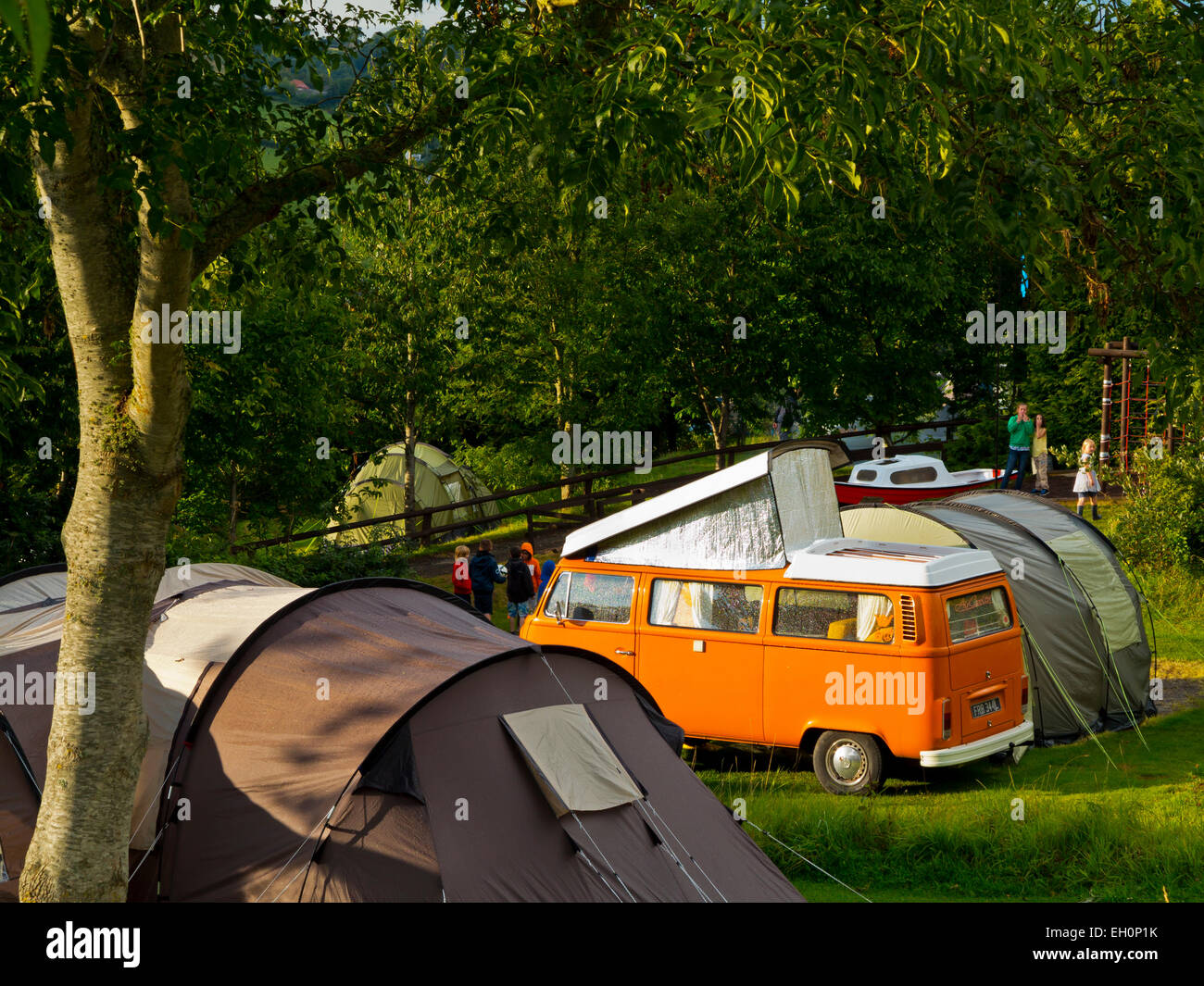 Orange VW Camper Van and tents at Hook Farm Campsite Uplyme on the  Dorset Devon border England UK Stock Photo