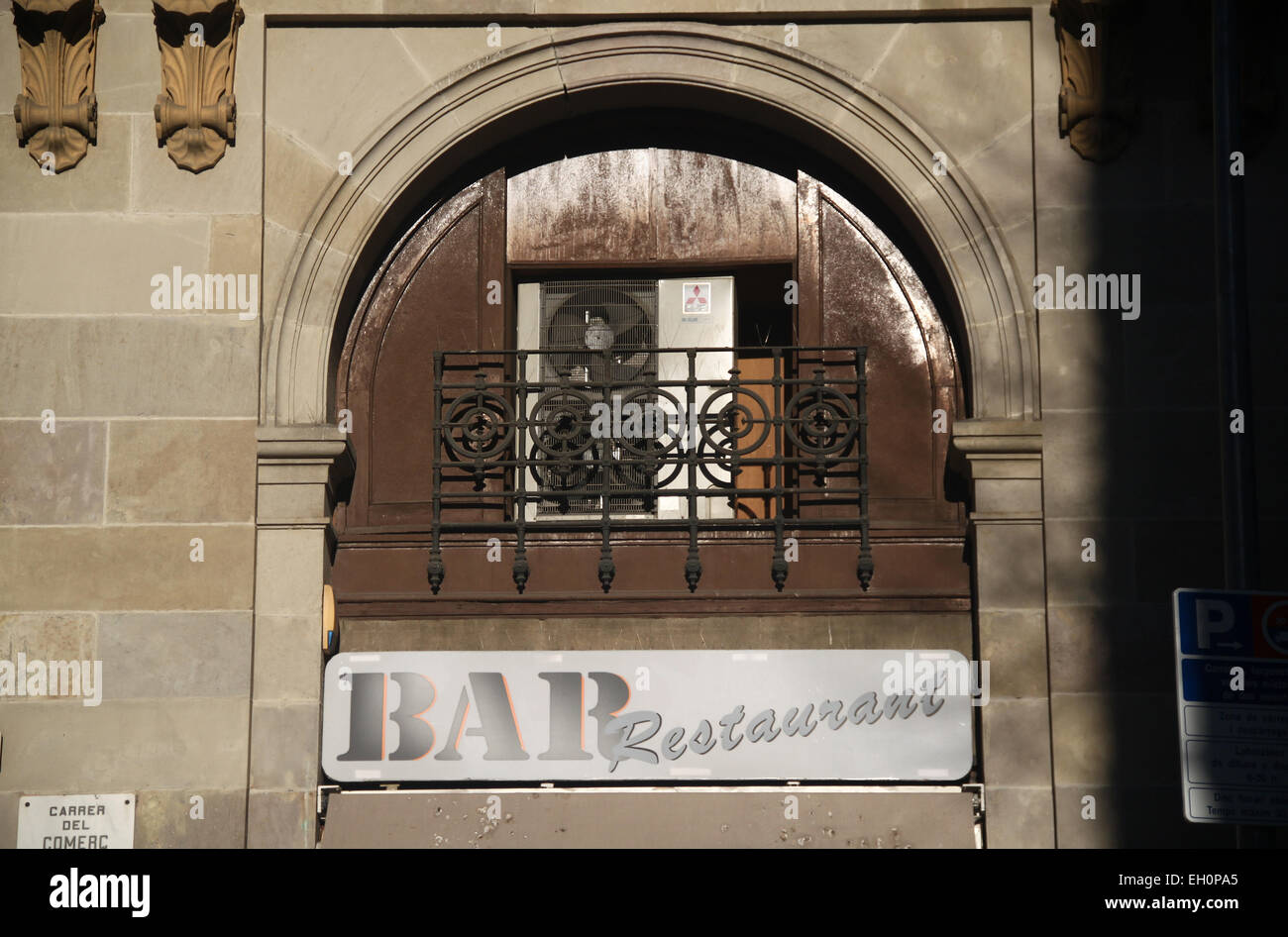 Air conditioning units in arched alcove above sign for Bar Restaurant in  Carrer del Comerç, Barcelona, Catalonia, Spain Stock Photo - Alamy