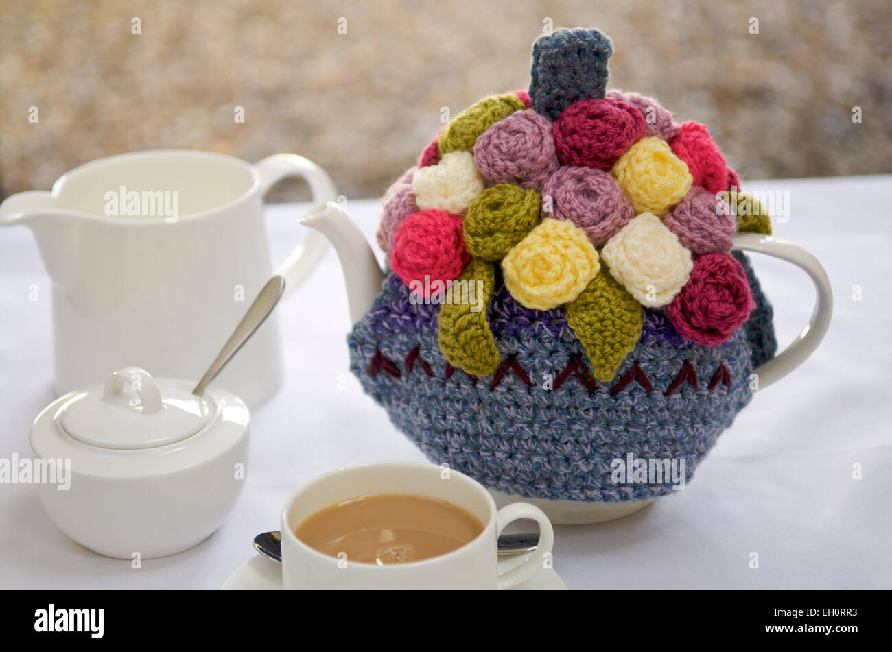 Ornate tea cosy on a teapot Stock Photo
