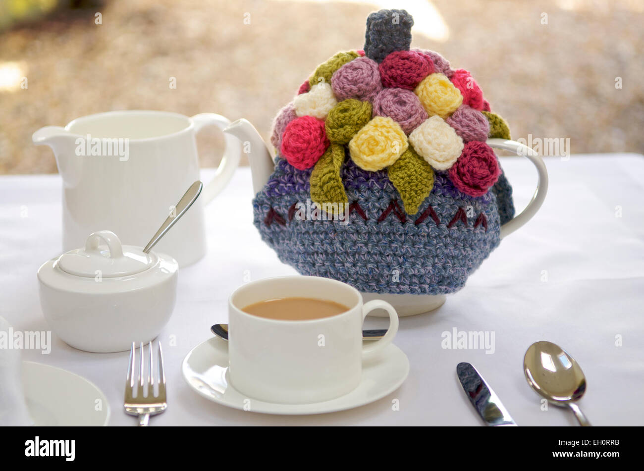 Ornate tea cosy on a teapot Stock Photo