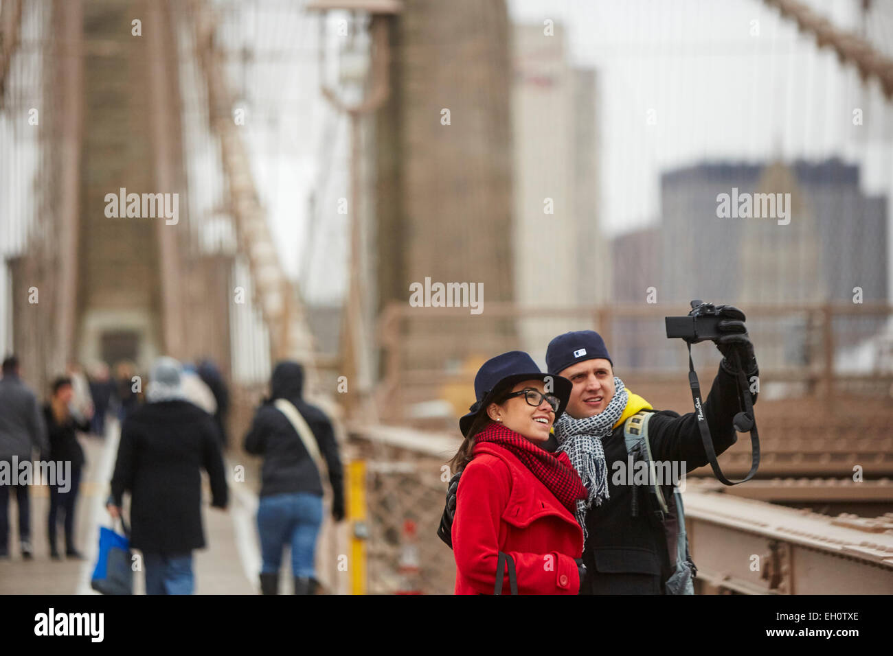 Tourists on Brooklyn Bridge taking selfie style picture of themselves  in Manhattan in New York North America USA Stock Photo