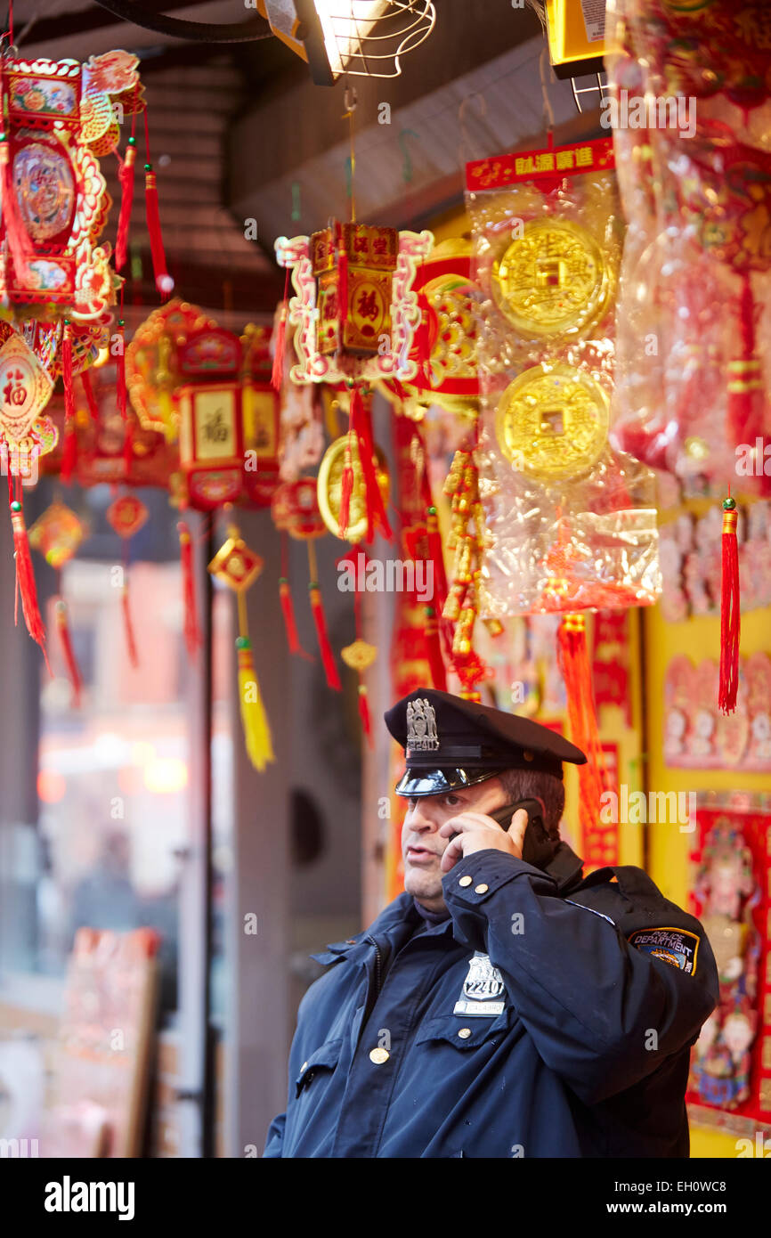 NYPD police officer on his mobile phone near Canal Street Manhattan in New York North America USA Stock Photo