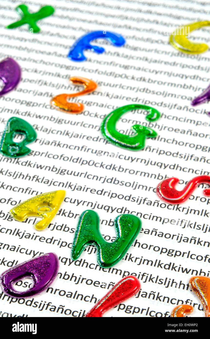 letters of different colors on a printed paper with nonsense words in the background, symbolizing the effect of printed words to Stock Photo