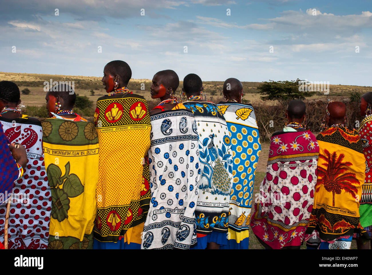 Rear view of Masai Women wearing the traditional shawls called Kangas, in a village near the Masai Mara, East Africa Stock Photo