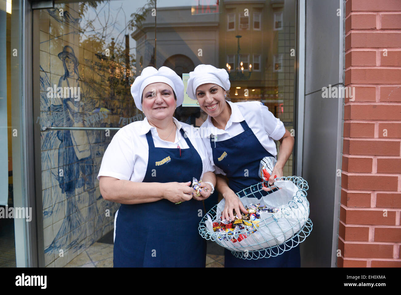 Two ladies from Teixeiras Bakery giving away candy at the front door of the business. Newark, New Jersey. USA. Stock Photo