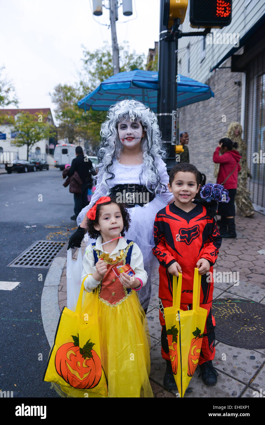 Three young dressed up kids posing in their Halloween costumes in the streets of Newark, New Jersey USA. 2013. Stock Photo