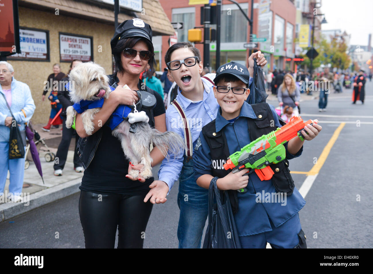 Two young kids posing with a young woman that holds a dog during Halloween 2013 in the streets of Newark, New Jersey USA. Stock Photo