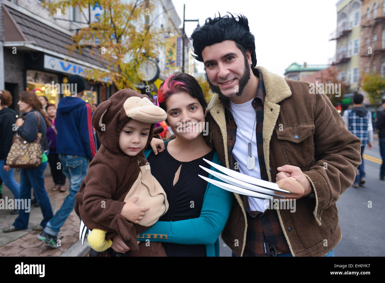 Mother and father dressed as Wolverine holding their son dressed as a monkey during the Halloween 2013 in Newark, New Jersey. Stock Photo