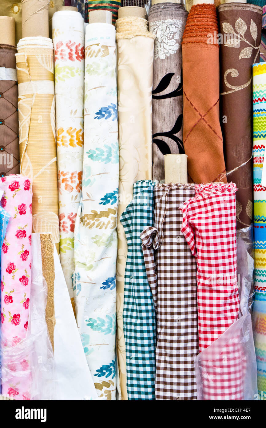 Colorful rolls of patterned fabric on sale at a market Stock Photo