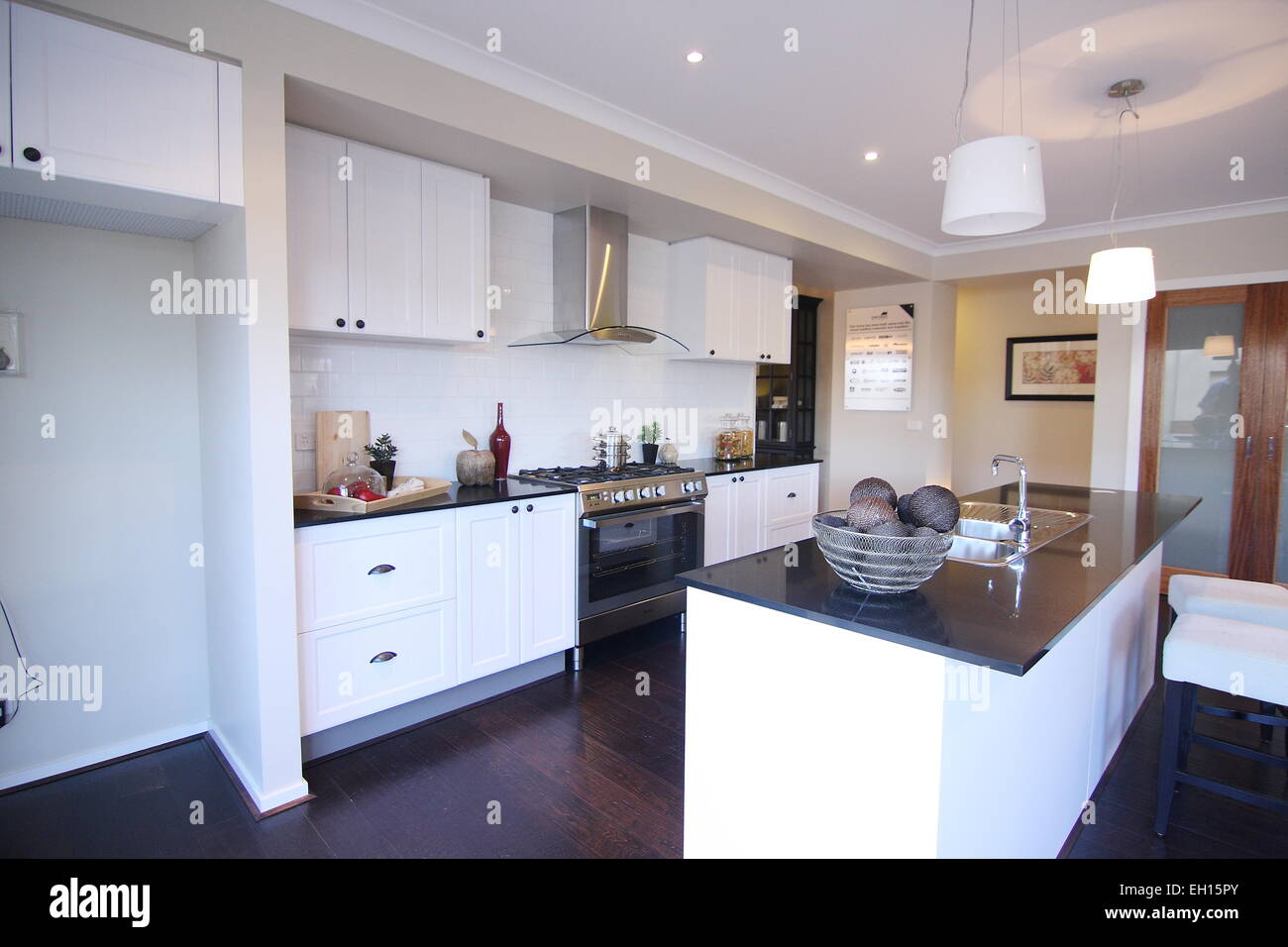 Modern White Kitchen with wooden flooring Stock Photo - Alamy
