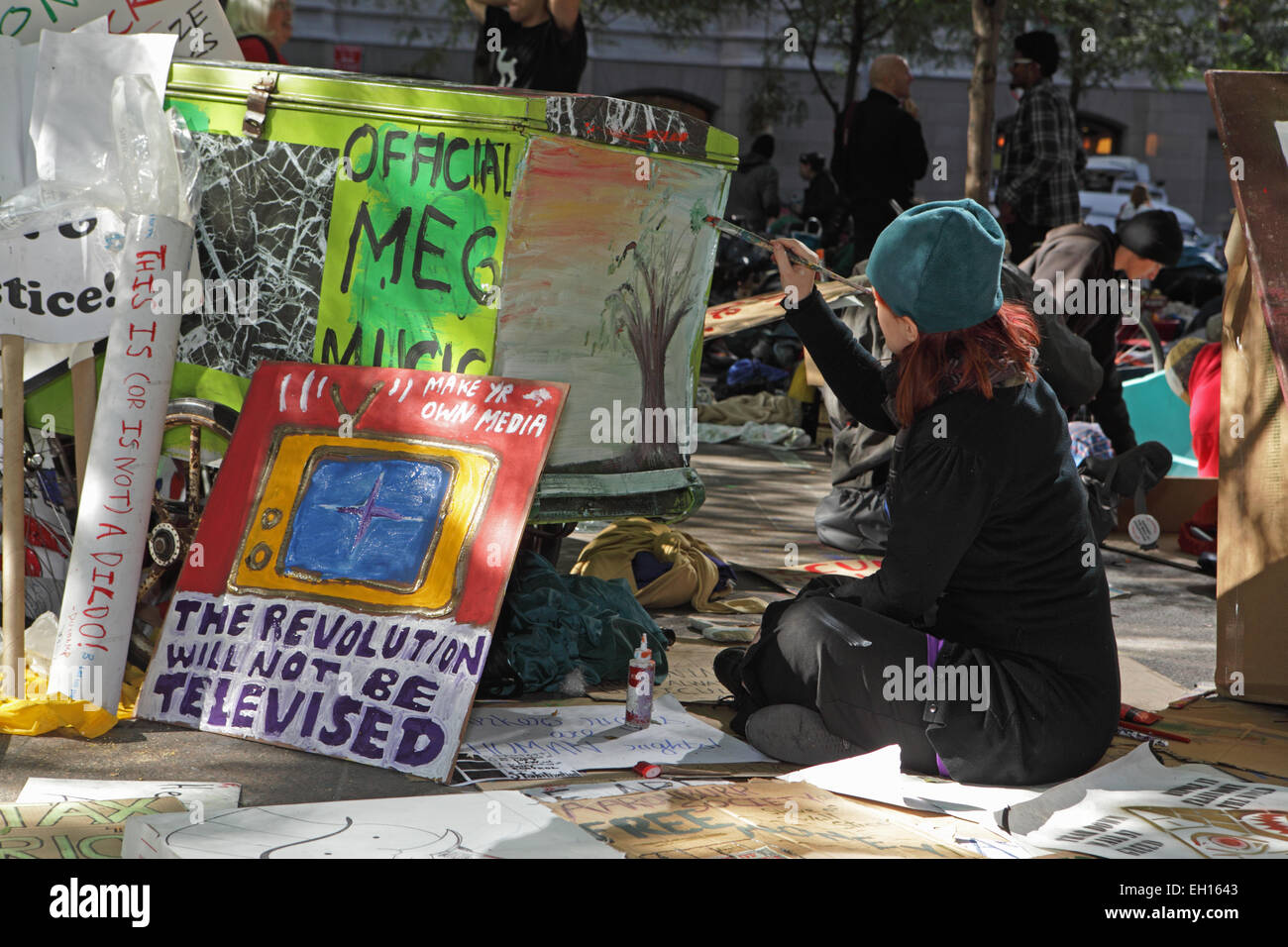 A young woman paints posters at the Occupy Wall Street protest in Zuccotti Park, New York Stock Photo