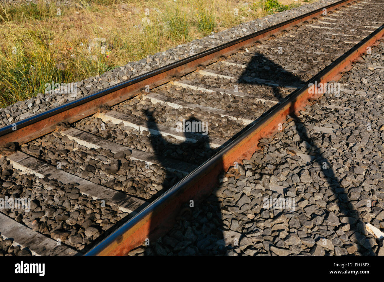 Shadow of a man on a train track Stock Photo