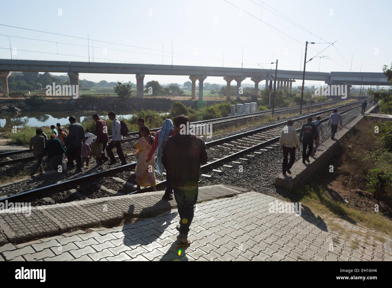 Residents cross the railway tracks at the Hitech City station in Hyderabad on January 11,2015 Stock Photo