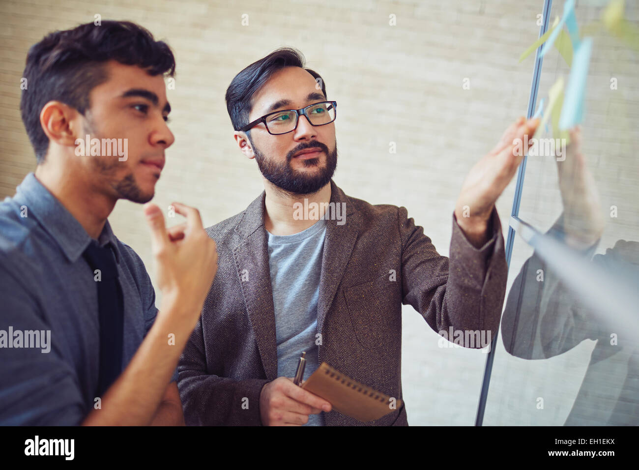 Two colleagues looking at their notes with tasks Stock Photo - Alamy