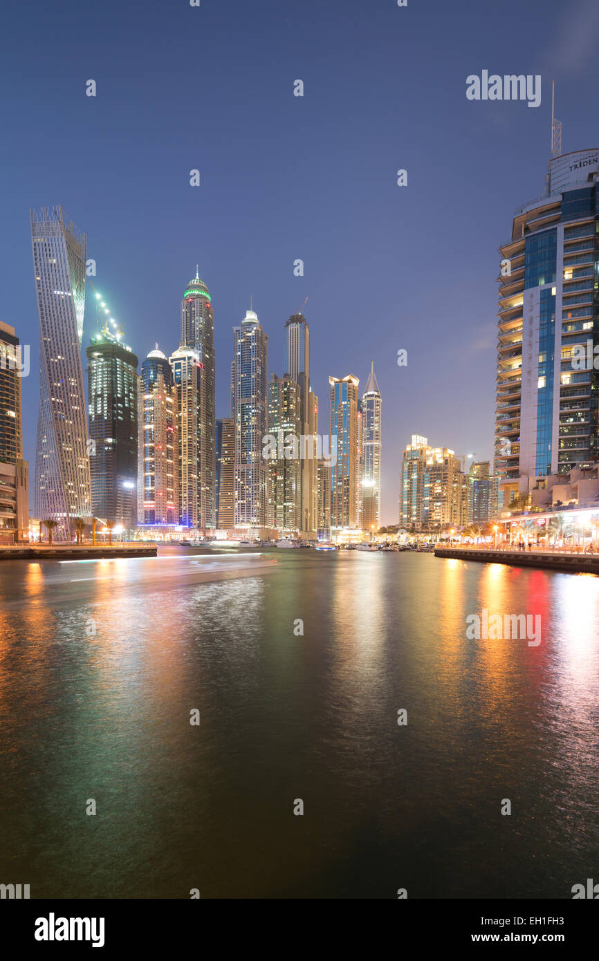 UAE, Dubai, city skyline with the iconic twisted "Cayman Tower" and Dubai Marina at night. Stock Photo