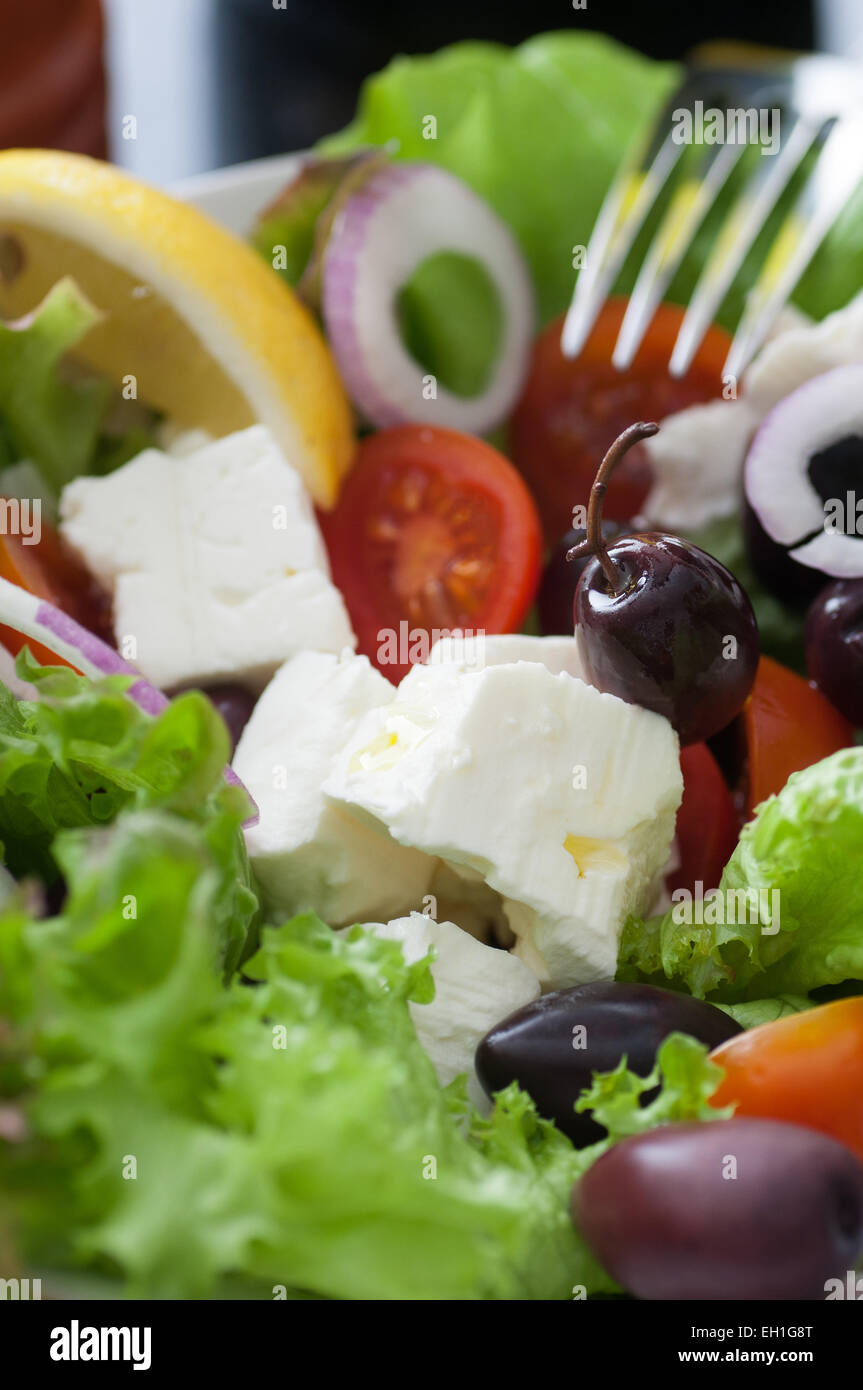 Green salad feta cheese, black olives, tomatoes, spanish onion. Served with olive oil, pepper and lemon. Stock Photo