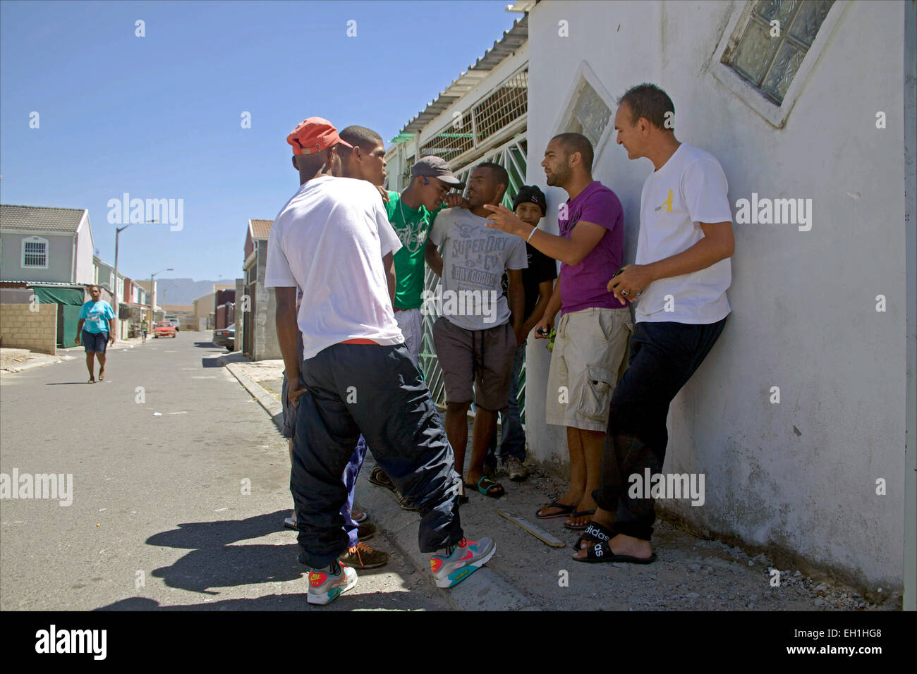 Hanover Park, South Africa. 17th Feb, 2015. CeaseFire Team member Wilfred Mckay (far right) talks to a group of young gangsters in the streets of Hanover Park, South Africa, 17 February 2015. Photo: Kristin Palitza/dpa/Alamy Live News Stock Photo