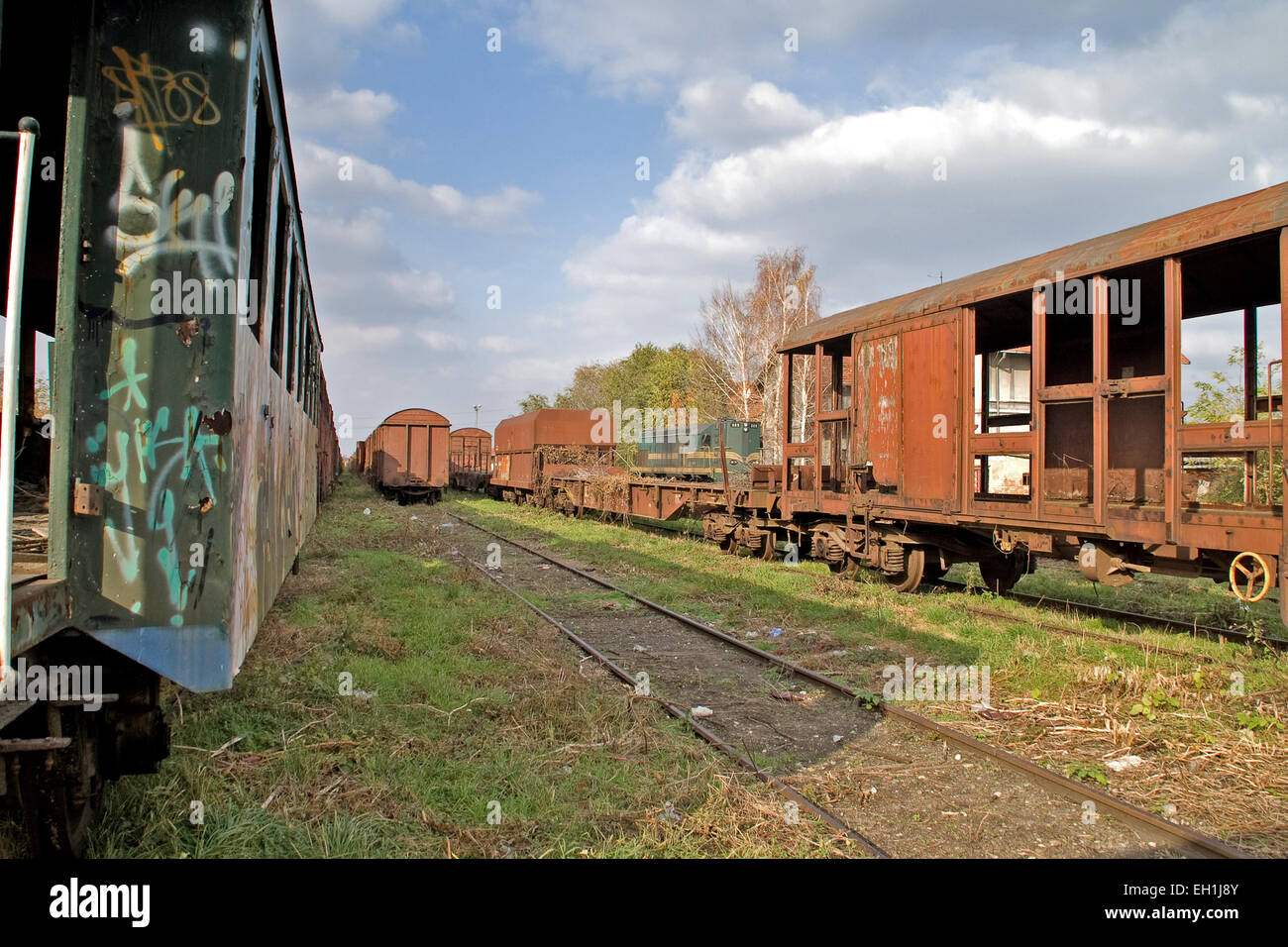 Passing locomotive near the old railway carriages on the siding waiting to cassation or repair. Stock Photo