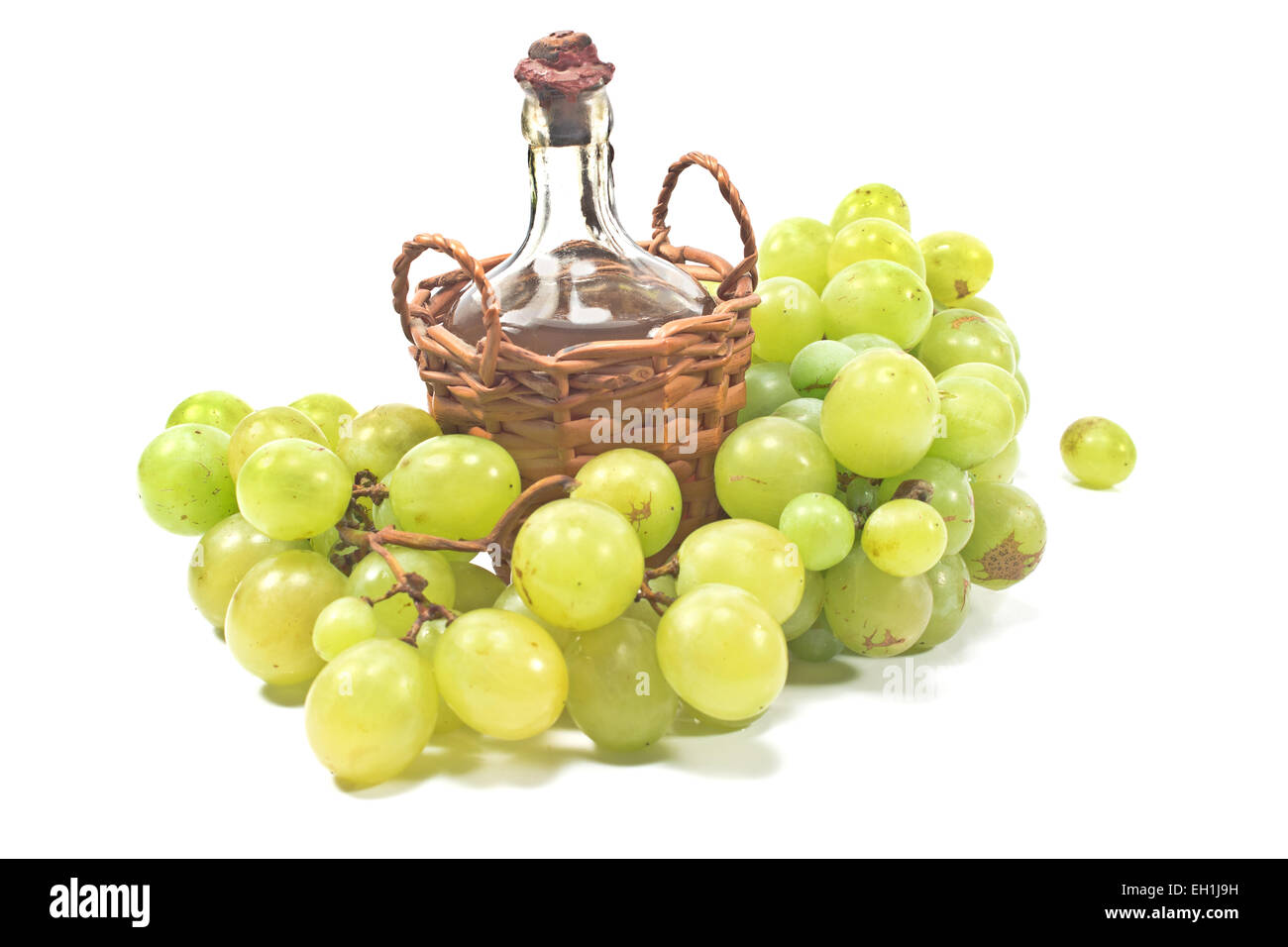 Old sealed bottle of wine and white grape isolated on white Stock Photo