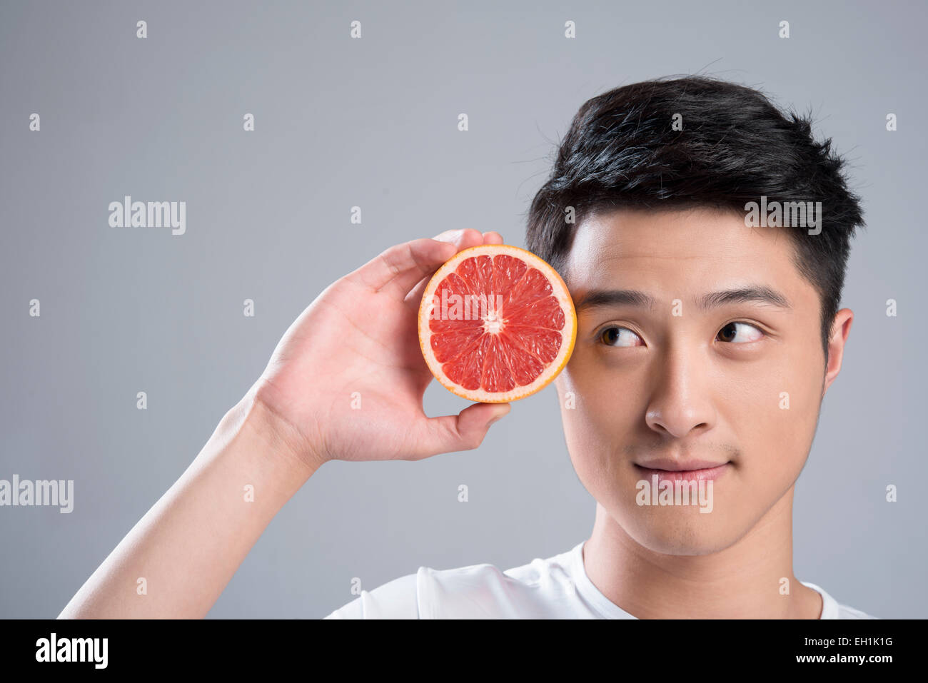Young man eating grapefruit Stock Photo Alamy