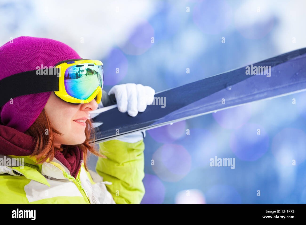 Close-up of happy woman in mask holding ski Stock Photo