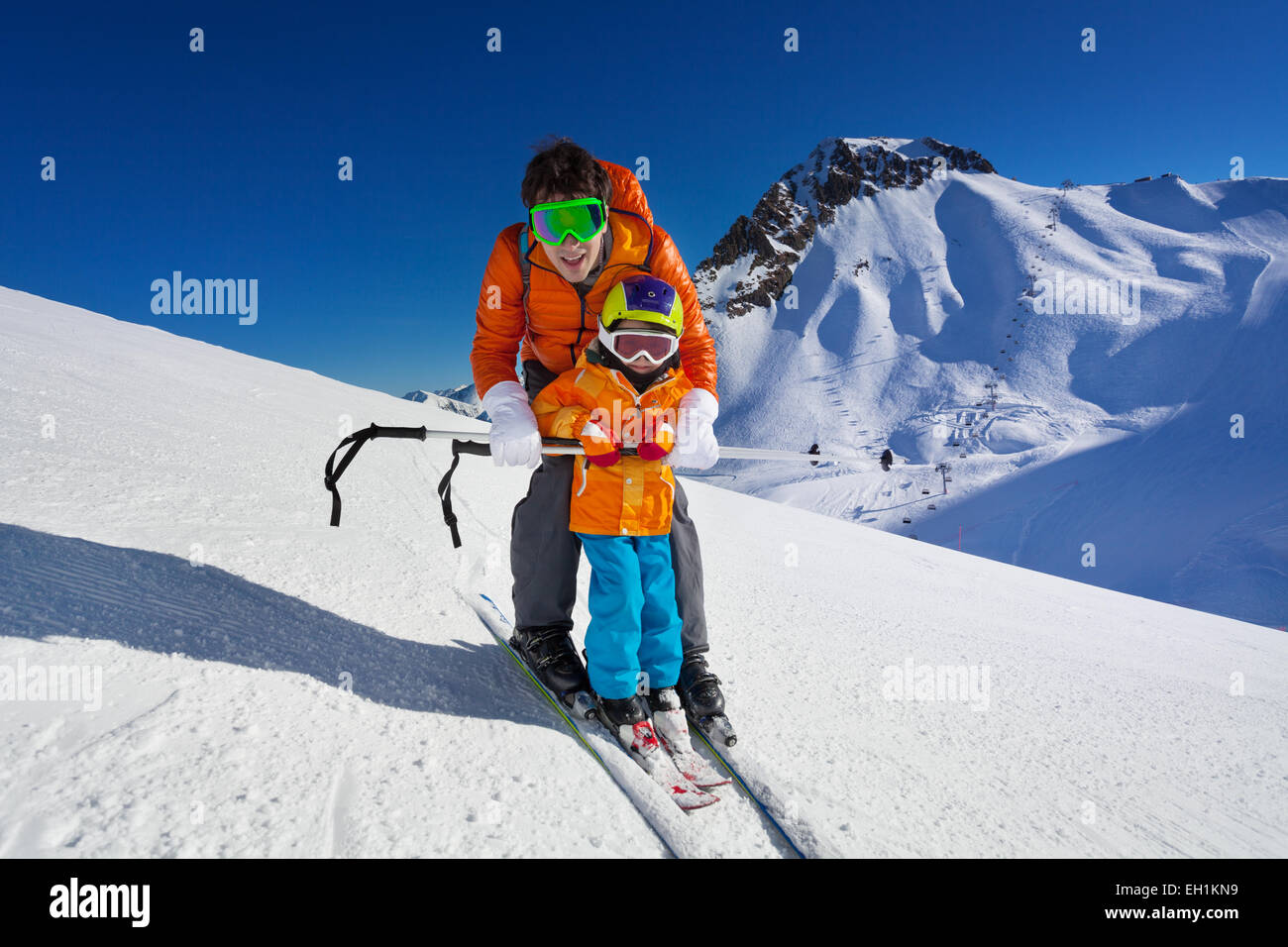Father give mountain ski lesson to little boy Stock Photo