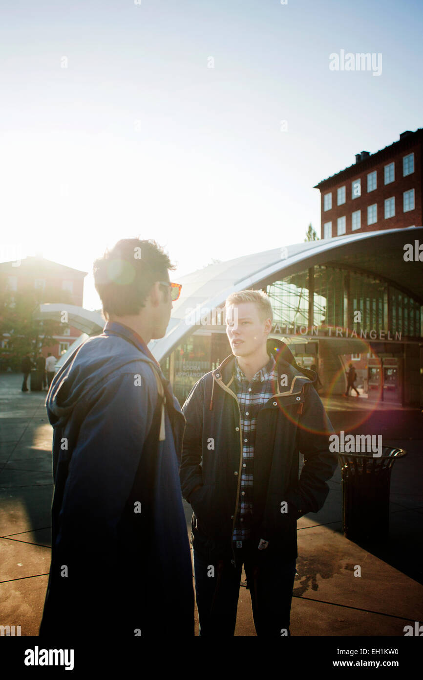 Businessmen communicating outside railway station Stock Photo - Alamy