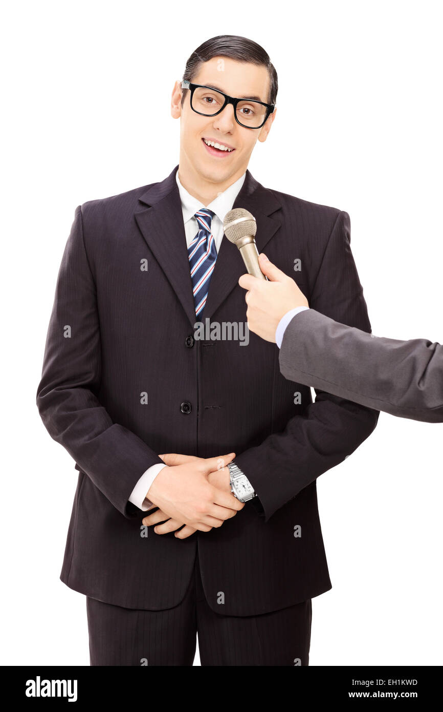 Vertical shot of a young businessman being interviewed isolated on white background Stock Photo