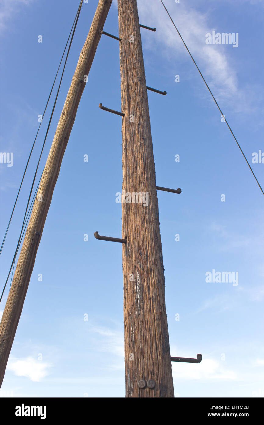 Old telephone wooden pole with rungs for climbing over sky Stock Photo