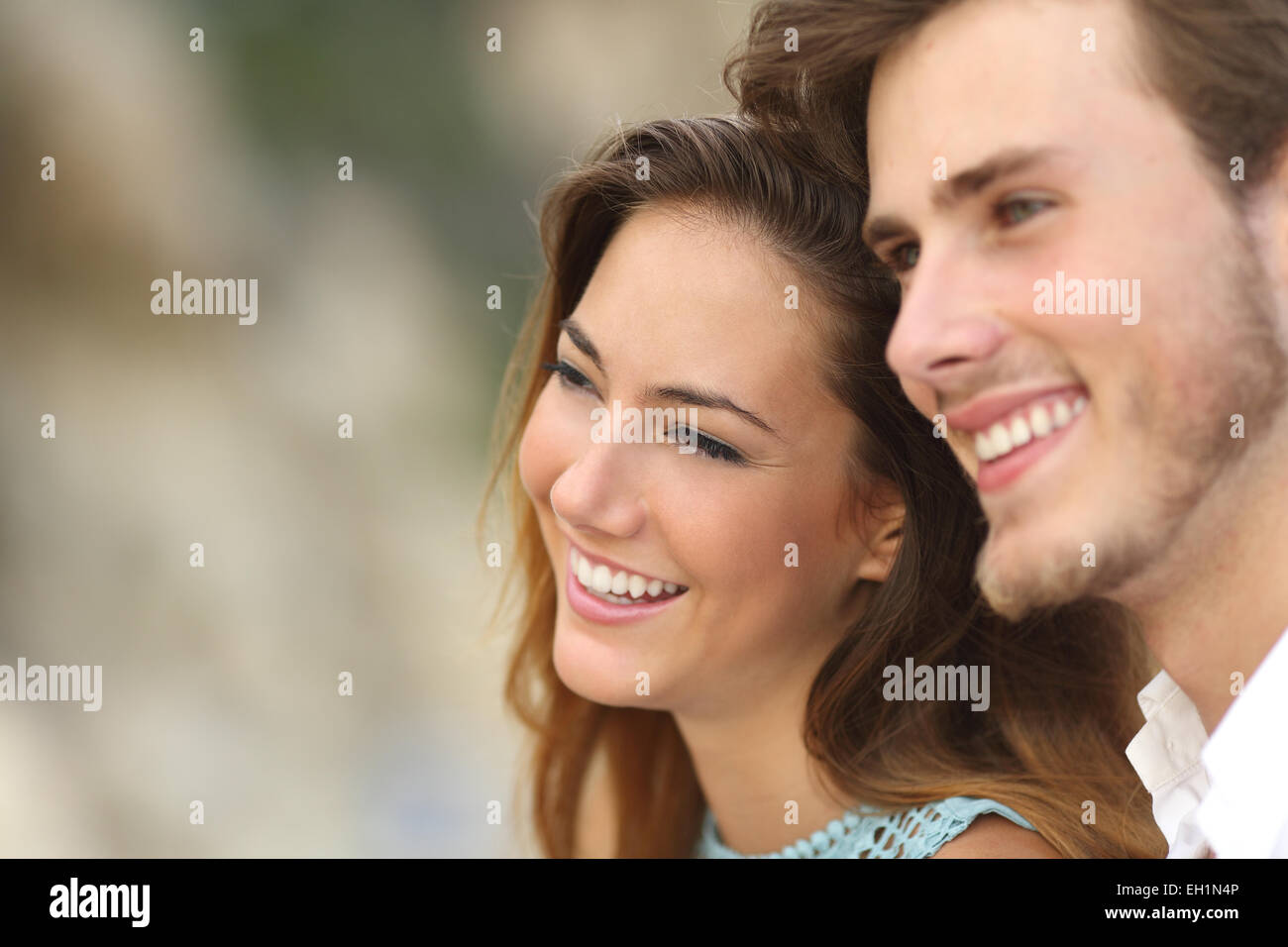 Happy couple in love looking away together with an unfocused background Stock Photo