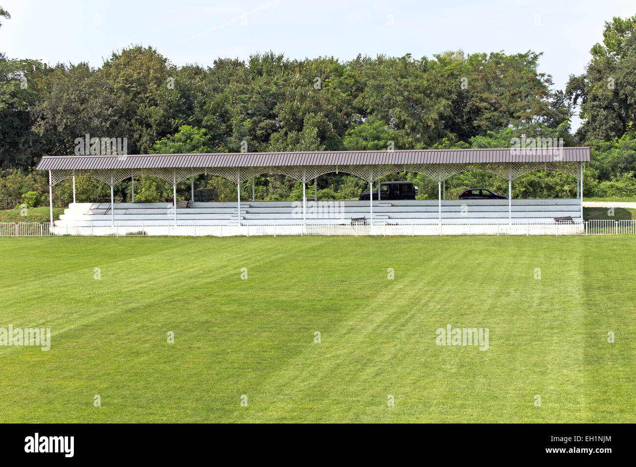 Wooden grandstand with roof and football field Stock Photo