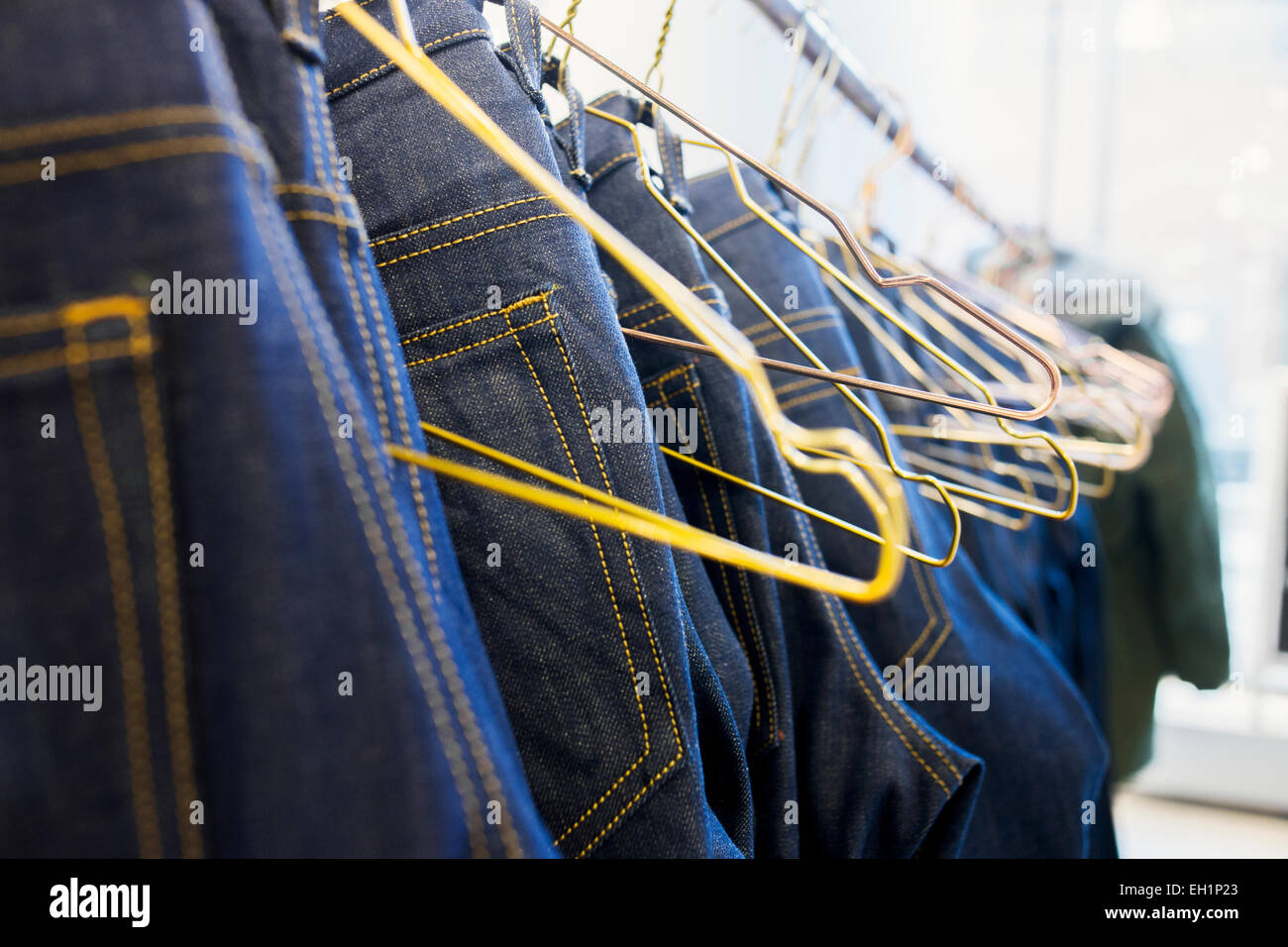 Jeans hanging from rack in factory Stock Photo Alamy