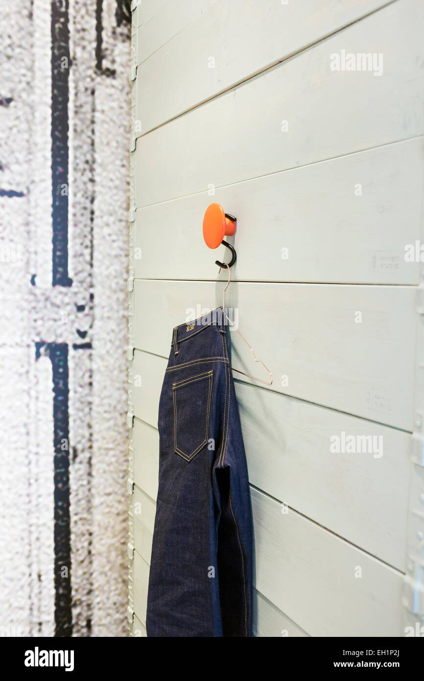 Jeans hanging from hook in changing room at factory Stock Photo Alamy