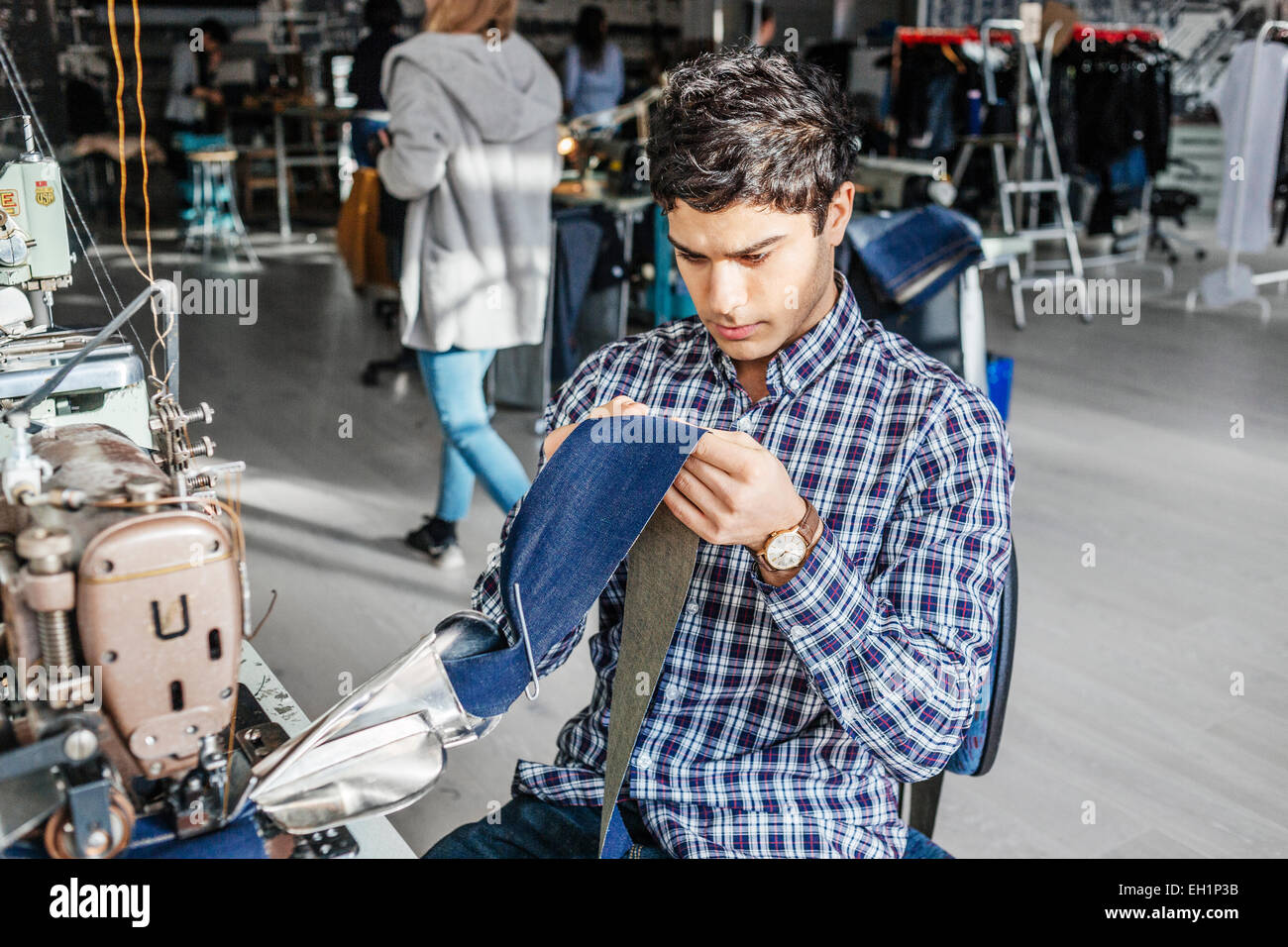 Sitting sewing machine working holding smiling textile industry