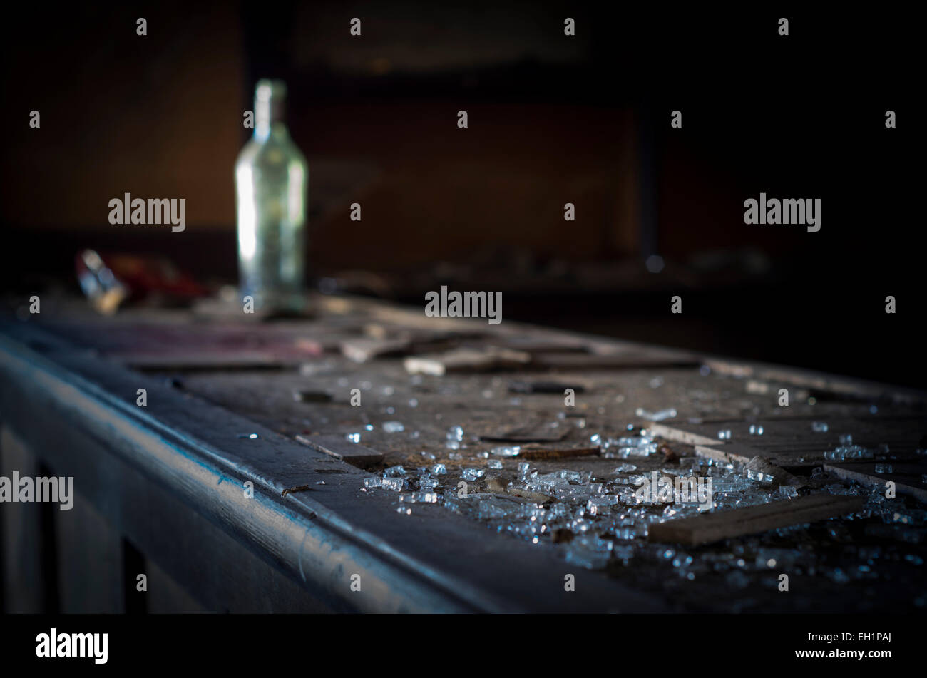 Broken glass and bottle on bar of derelict public house, UK Stock Photo
