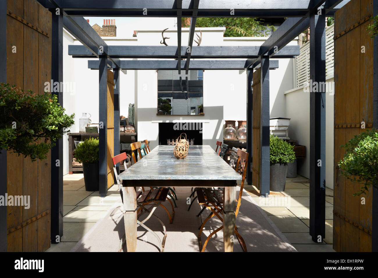 Zinctopped table and chairs in paved back yard of residential house