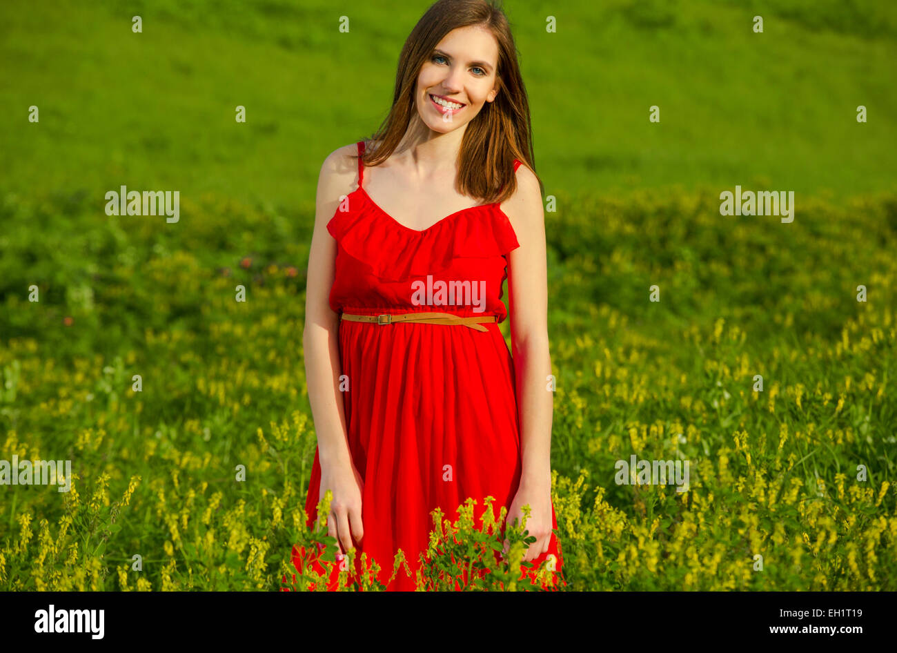 Young beautiful woman in a red dress smiling Stock Photo - Alamy