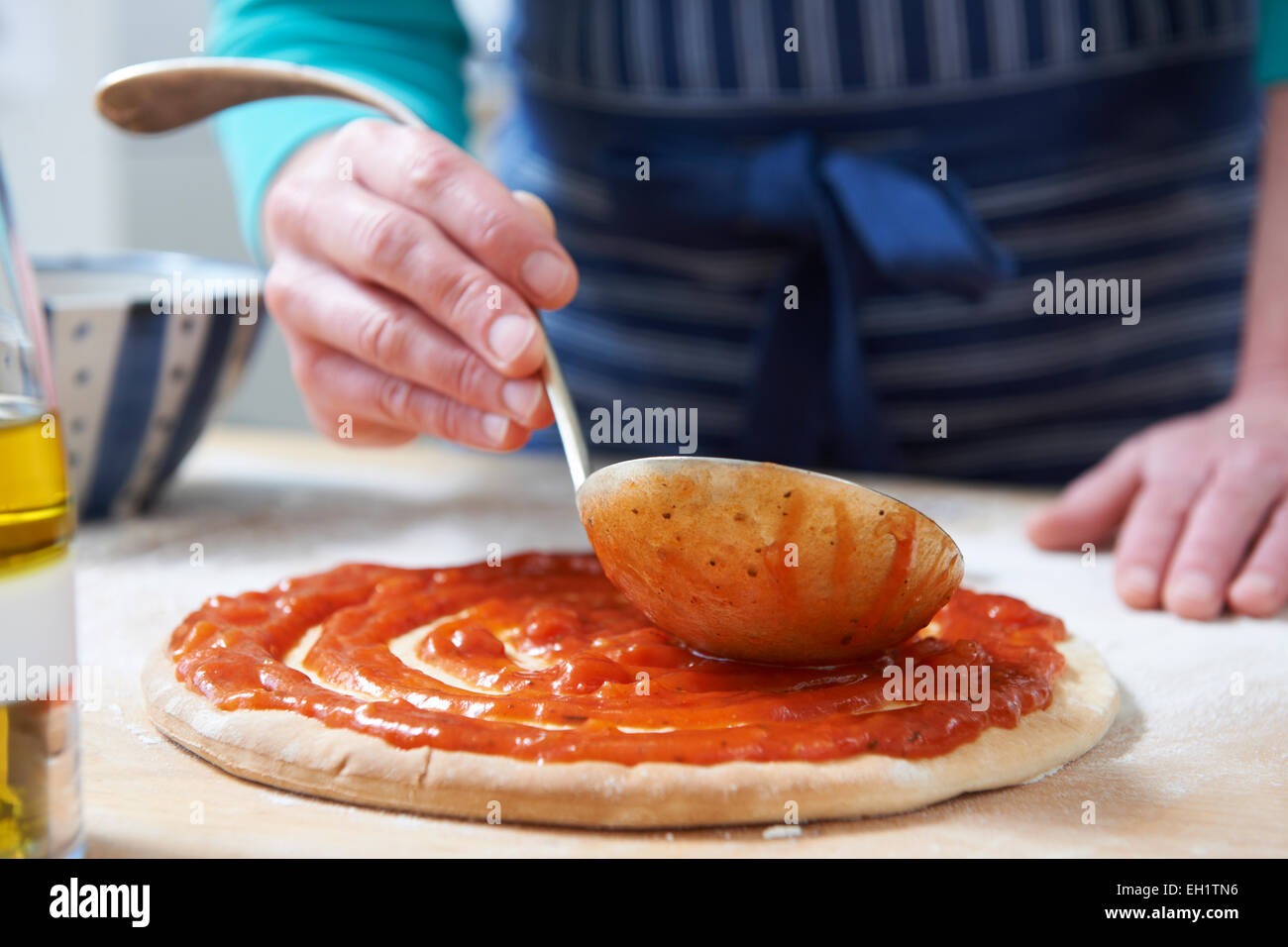 Close Up Of Adding Tomato Sauce To Pizza Base Stock Photo Alamy