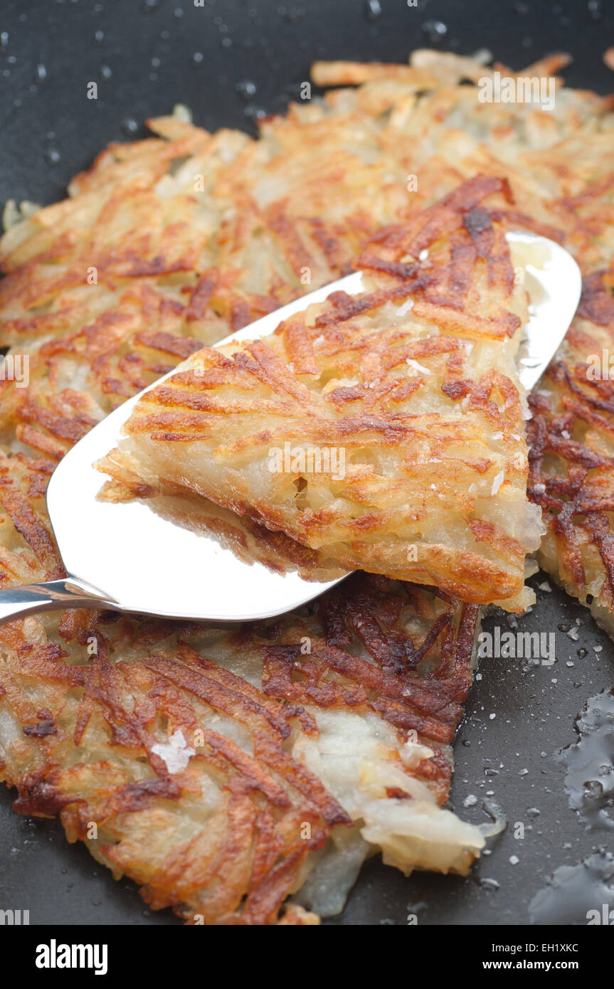 Hash brown with sea salt in a frying pan. Stock Photo