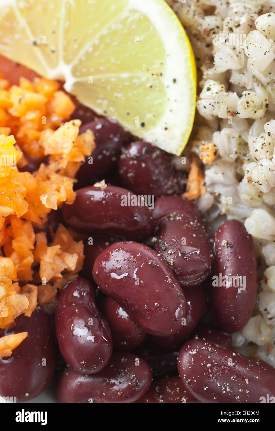 Prepared kidney beans, grated carrot and buckwheat. Served with lemon, olive oil and black pepper. Stock Photo