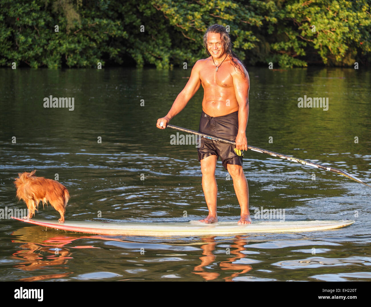 Kauai resident and dog navigate the Hanalei River in Hanalei, Kauai Stock Photo