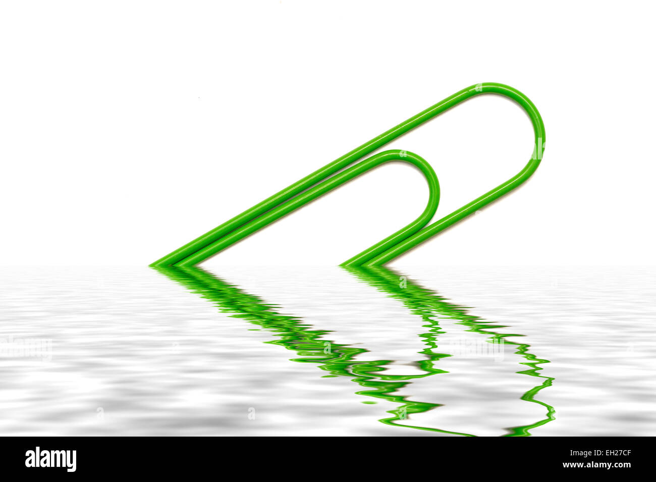 A Giant green paper clip digitally mirrored into a pool of water Stock Photo