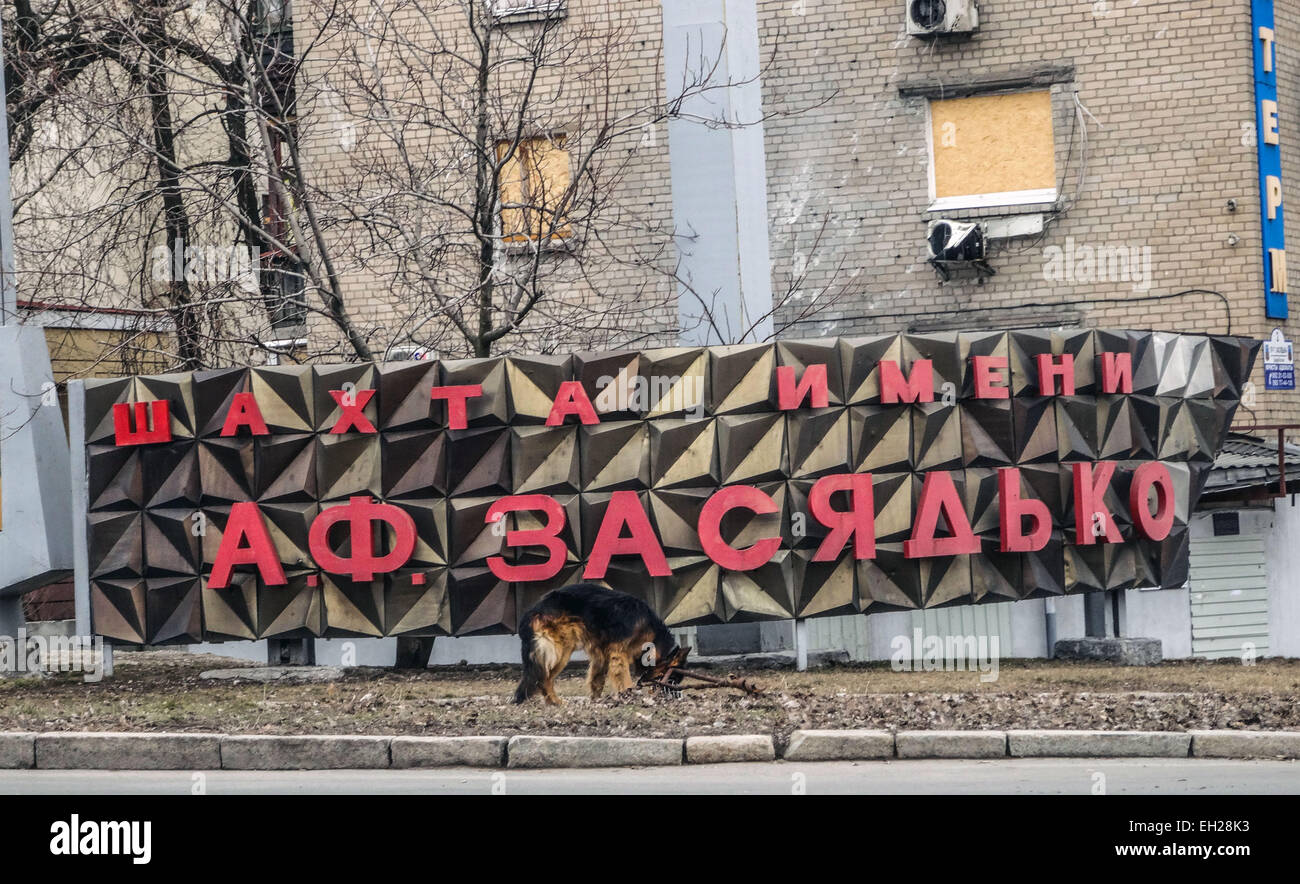 Dog wanders near a sign that says 