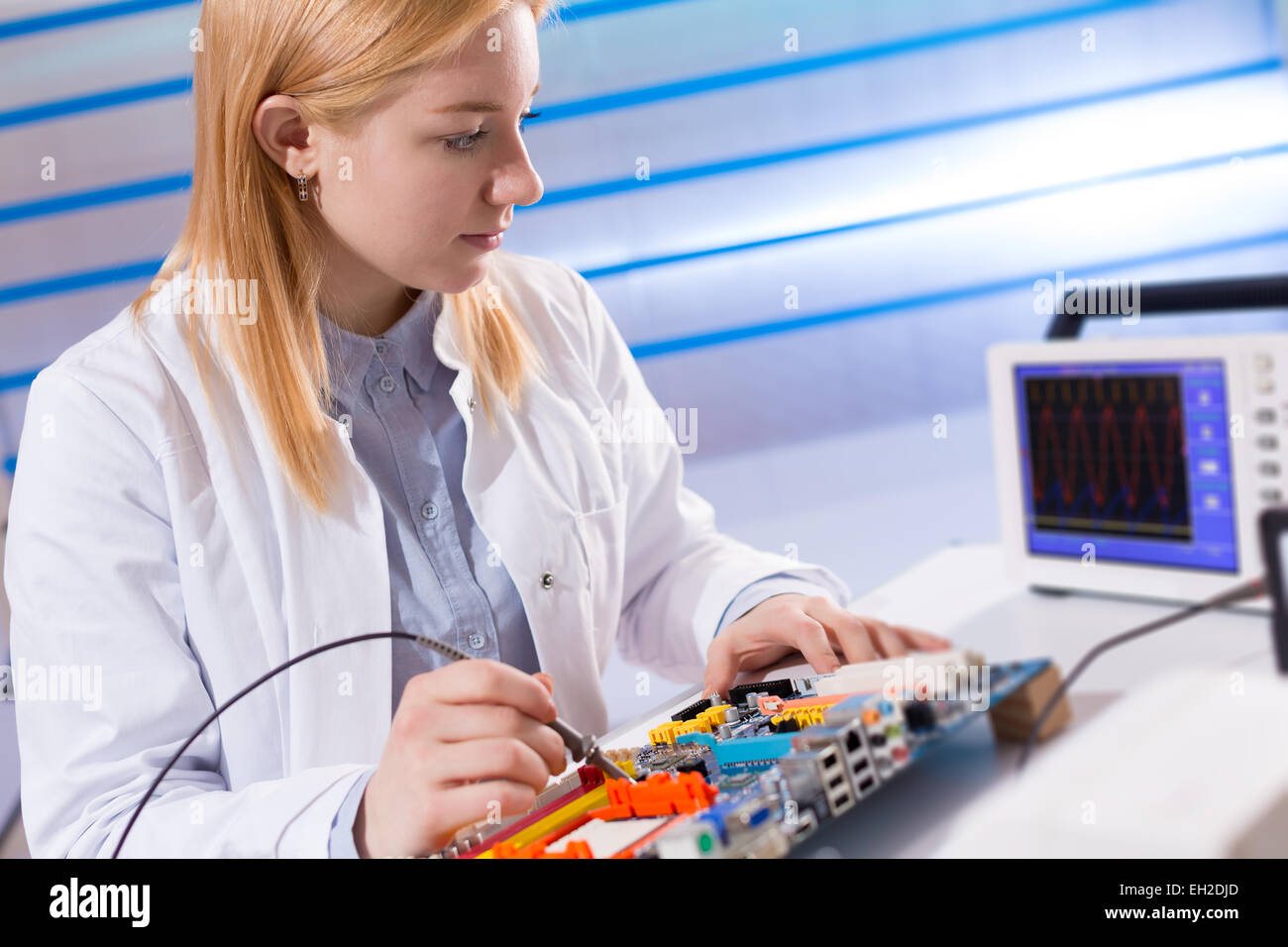 girl with a tester and a printed circuit board Stock Photo - Alamy