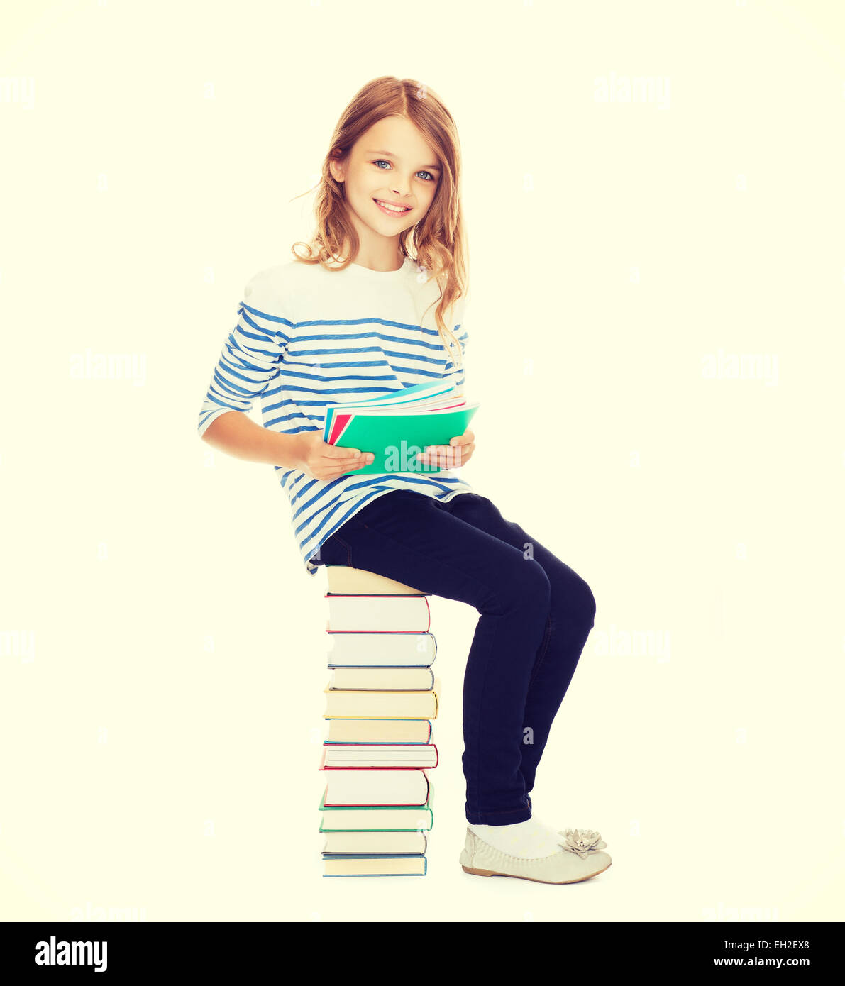 little student girl sitting on stack of books Stock Photo - Alamy