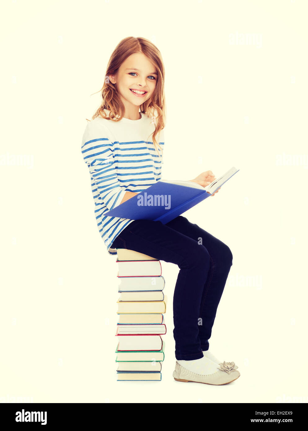 little student girl sitting on stack of books Stock Photo - Alamy